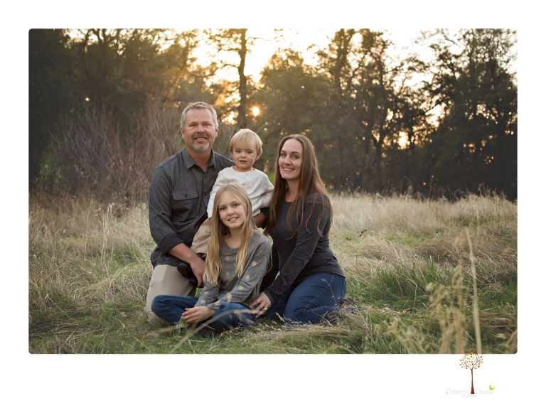 Sonora family photographer Christine Dibble Photography takes family portraits in a private vineyard as a family plays and climbs trees and rocks.