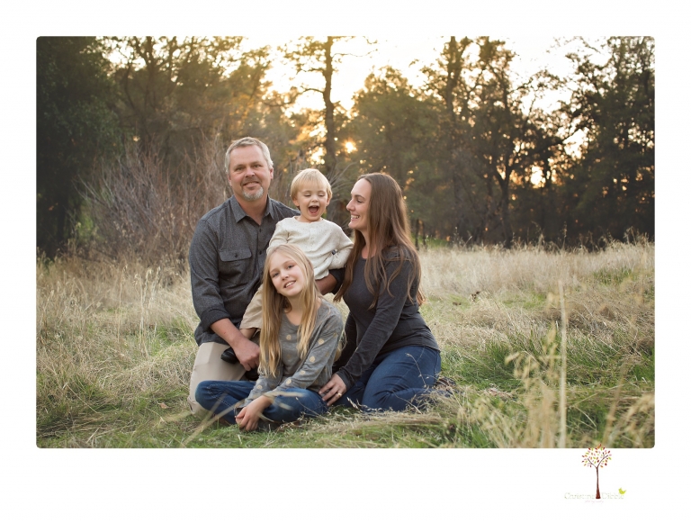 Sonora family photographer Christine Dibble Photography takes family portraits in a private vineyard as a family plays and climbs trees and rocks.