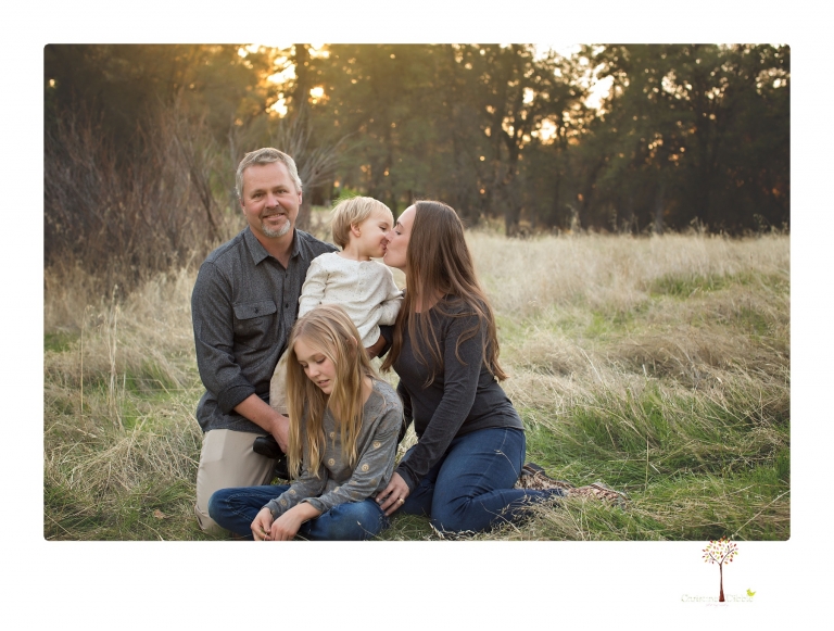 Sonora family photographer Christine Dibble Photography takes family portraits in a private vineyard as a family plays and climbs trees and rocks.