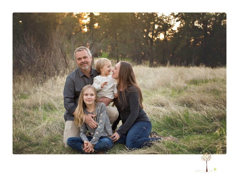 Sonora family photographer Christine Dibble Photography takes family portraits in a private vineyard as a family plays and climbs trees and rocks.