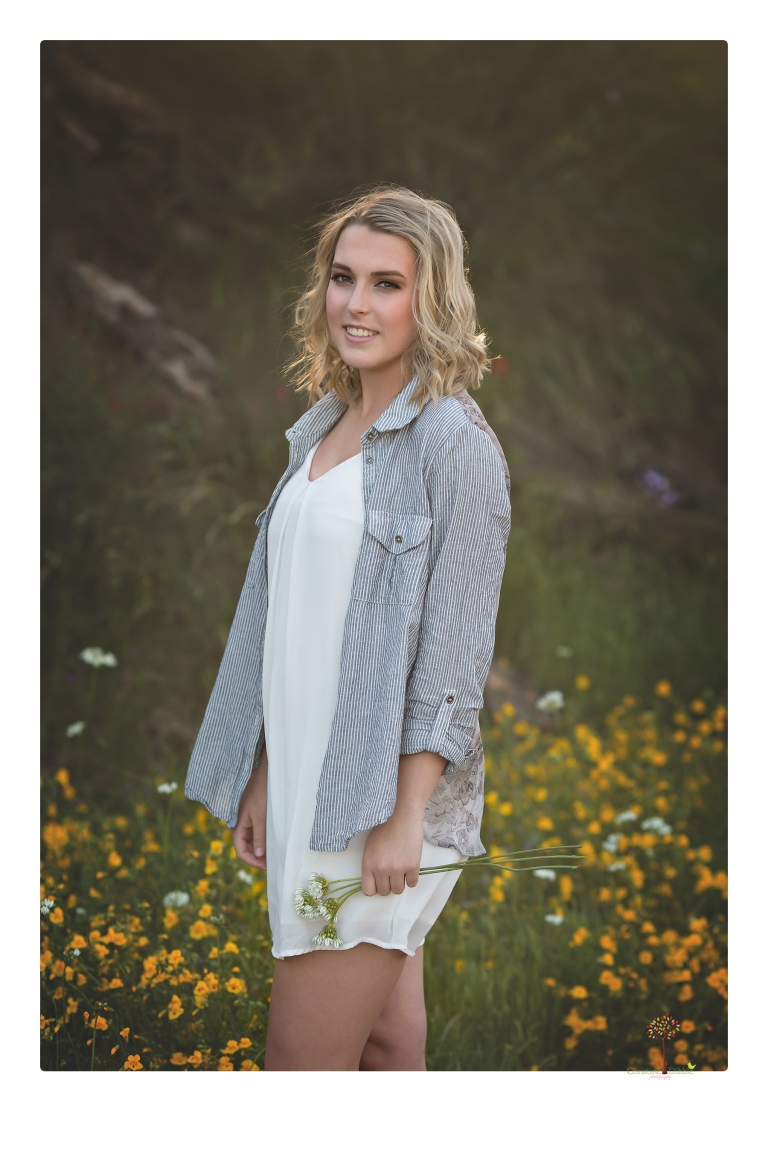 Sonora High senior portrait photographer Christine Dibble Photography takes senior portraits of a girl on her family's Chinese Camp ranch among wildflowers in a creek and with an American flag.