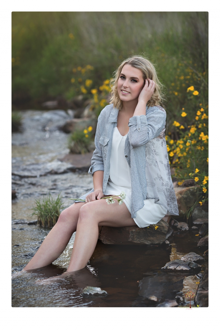 Sonora High senior portrait photographer Christine Dibble Photography takes senior portraits of a girl on her family's Chinese Camp ranch among wildflowers in a creek and with an American flag.