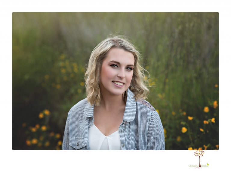 Sonora High senior portrait photographer Christine Dibble Photography takes senior portraits of a girl on her family's Chinese Camp ranch among wildflowers in a creek and with an American flag.