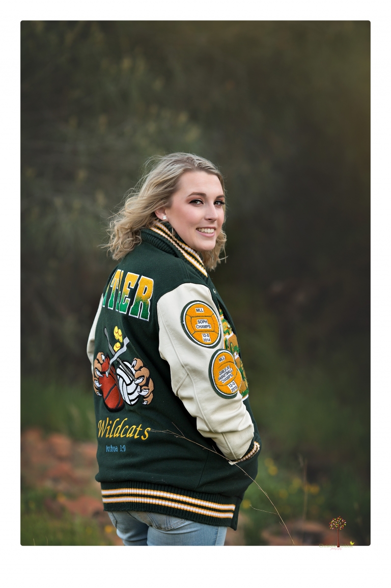 Sonora High senior portrait photographer Christine Dibble Photography takes senior portraits of a girl on her family's Chinese Camp ranch among wildflowers in a creek and with an American flag.