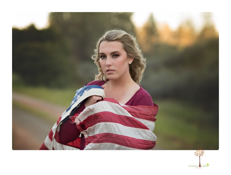 Sonora High senior portrait photographer Christine Dibble Photography takes senior portraits of a girl on her family's Chinese Camp ranch among wildflowers in a creek and with an American flag.