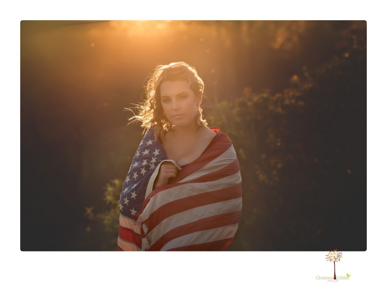 Sonora High senior portrait photographer Christine Dibble Photography takes senior portraits of a girl on her family's Chinese Camp ranch among wildflowers in a creek and with an American flag.
