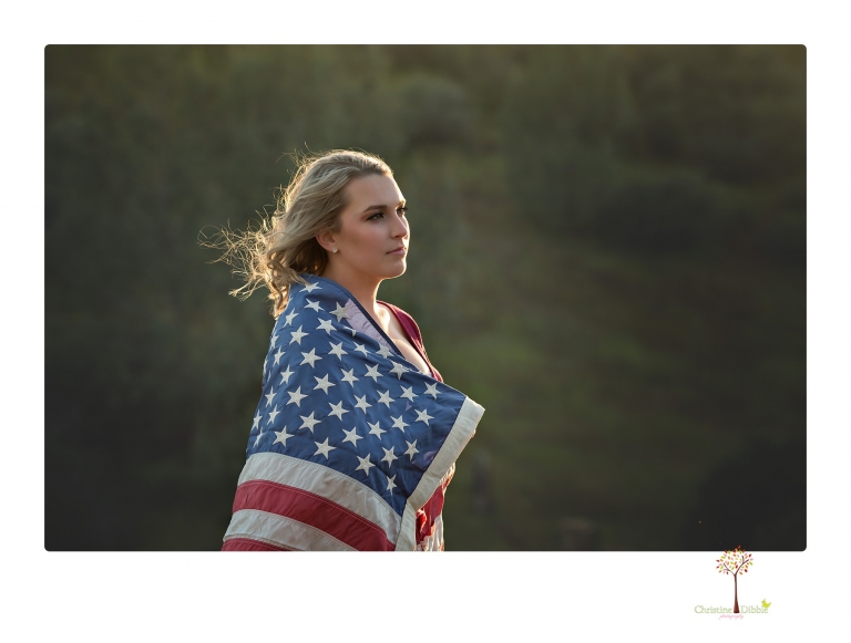 Sonora High senior portrait photographer Christine Dibble Photography takes senior portraits of a girl on her family's Chinese Camp ranch among wildflowers in a creek and with an American flag.