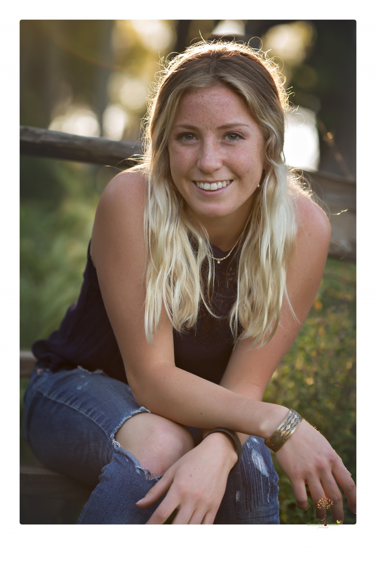 Sonora senior portrait photographer Christine Dibble Photography photographs a Sonora water polo graduate in her yard.