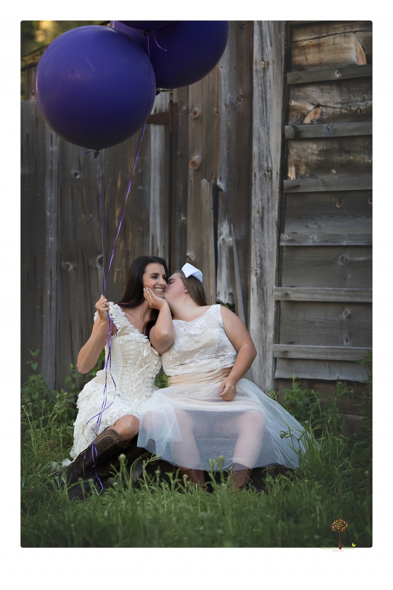 Sonora senior portrait photographer Christine Dibble Photography takes senior portraits of a girl in a lace dress with giant balloons on a velvet loveseat in a field.