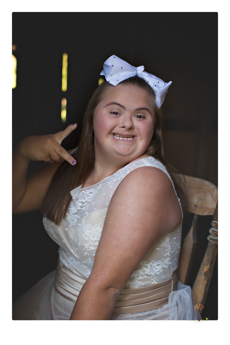 Sonora senior portrait photographer Christine Dibble Photography takes senior portraits of a girl in a lace dress with giant balloons on a velvet loveseat in a field.