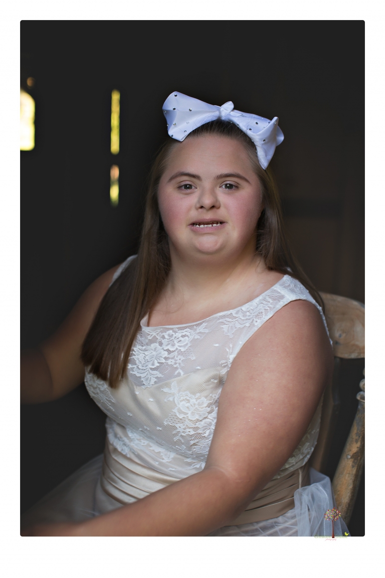 Sonora senior portrait photographer Christine Dibble Photography takes senior portraits of a girl in a lace dress with giant balloons on a velvet loveseat in a field.