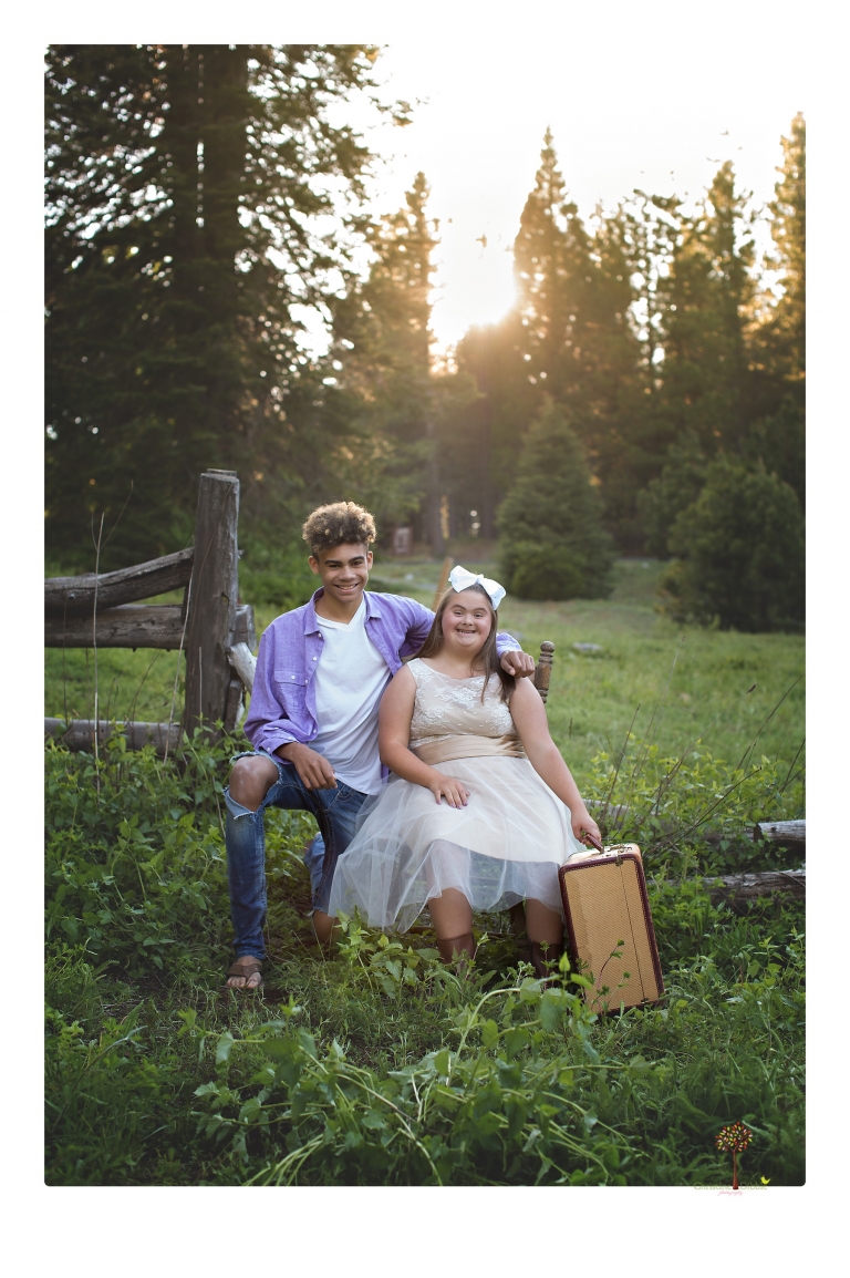 Sonora senior portrait photographer Christine Dibble Photography takes senior portraits of a girl in a lace dress with giant balloons on a velvet loveseat in a field.