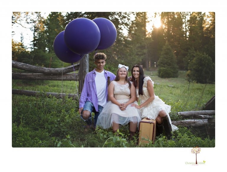 Sonora senior portrait photographer Christine Dibble Photography takes senior portraits of a girl in a lace dress with giant balloons on a velvet loveseat in a field.