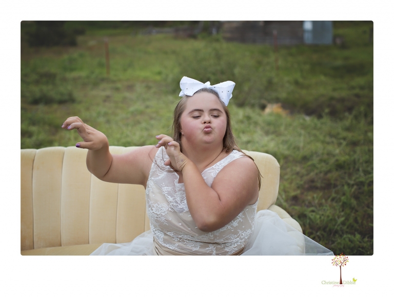 Sonora senior portrait photographer Christine Dibble Photography takes senior portraits of a girl in a lace dress with giant balloons on a velvet loveseat in a field.
