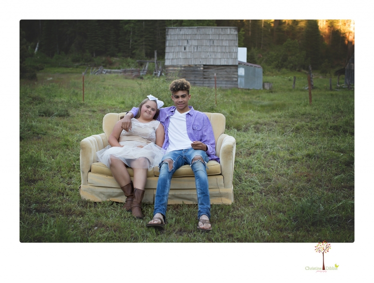 Sonora senior portrait photographer Christine Dibble Photography takes senior portraits of a girl in a lace dress with giant balloons on a velvet loveseat in a field.