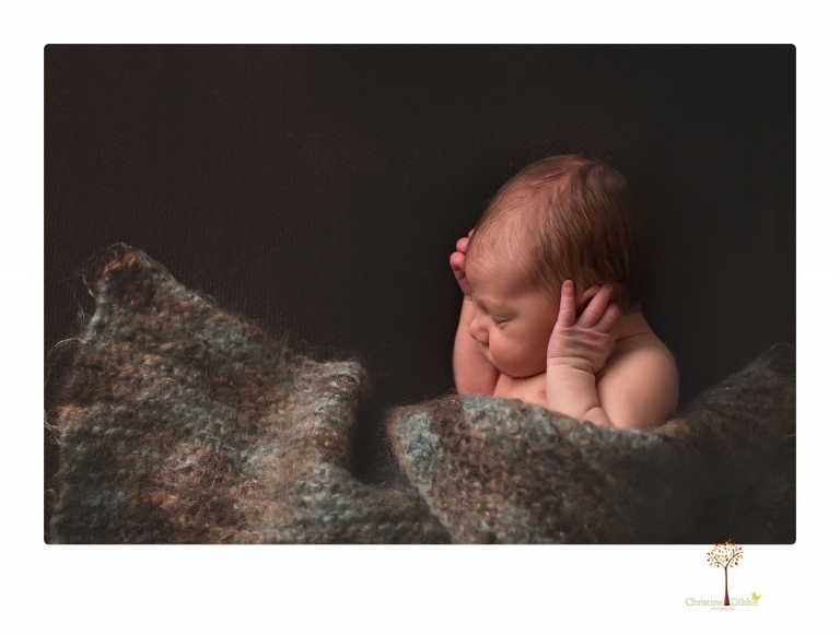 Sonora Newborn Photographer Christine Dibble Photography takes newborn portraits of a baby in a ski boot and with his parents.