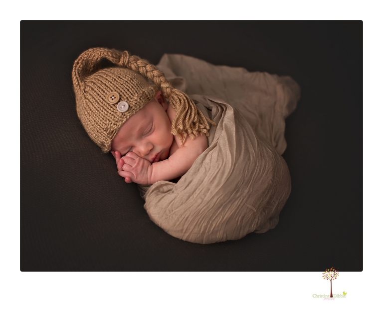 Sonora Newborn Photographer Christine Dibble Photography takes newborn portraits of a baby in a ski boot and with his parents.