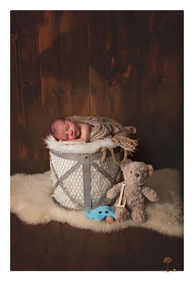 Sonora Newborn Photographer Christine Dibble Photography takes newborn portraits of a baby in a ski boot and with his parents.