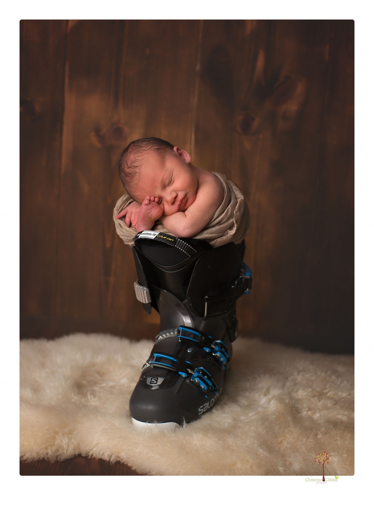Sonora Newborn Photographer Christine Dibble Photography takes newborn portraits of a baby in a ski boot and with his parents.