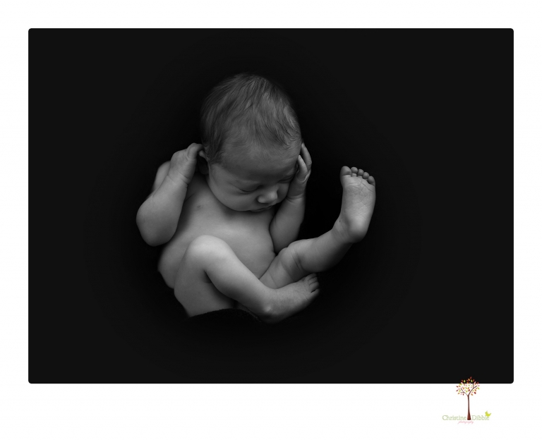 Sonora Newborn Photographer Christine Dibble Photography takes newborn portraits of a baby in a ski boot and with his parents.