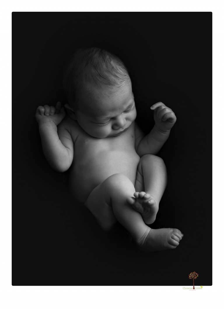 Sonora Newborn Photographer Christine Dibble Photography takes newborn portraits of a baby in a ski boot and with his parents.