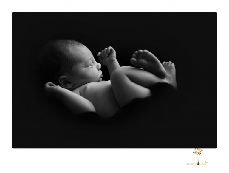 Sonora Newborn Photographer Christine Dibble Photography takes newborn portraits of a baby in a ski boot and with his parents.