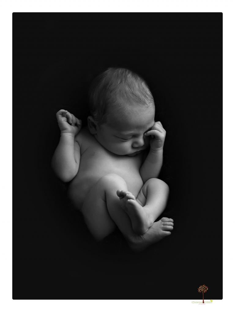 Sonora Newborn Photographer Christine Dibble Photography takes newborn portraits of a baby in a ski boot and with his parents.