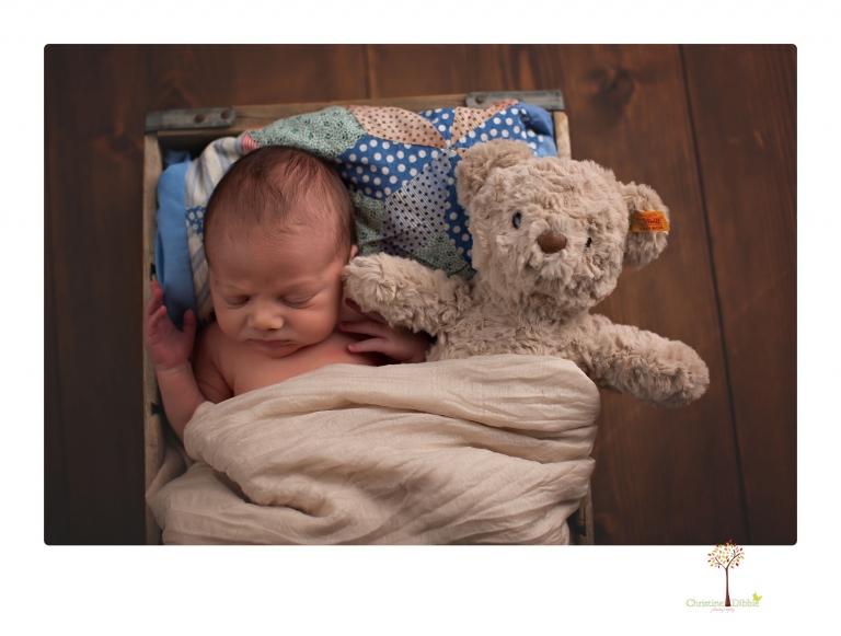 Sonora Newborn Photographer Christine Dibble Photography takes newborn portraits of a baby in a ski boot and with his parents.