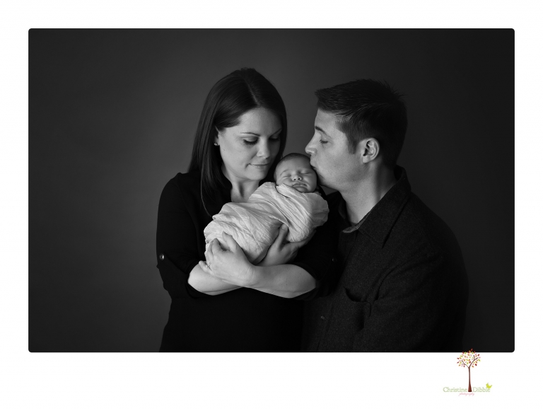 Sonora Newborn Photographer Christine Dibble Photography takes newborn portraits of a baby in a ski boot and with his parents.