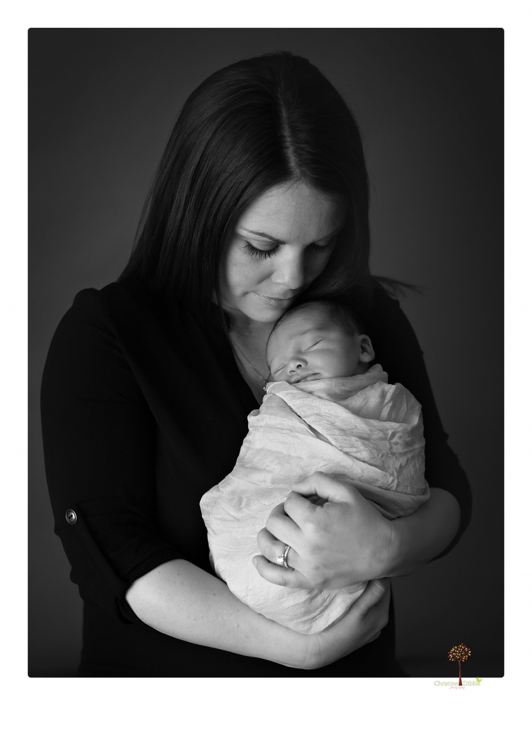 Sonora Newborn Photographer Christine Dibble Photography takes newborn portraits of a baby in a ski boot and with his parents.