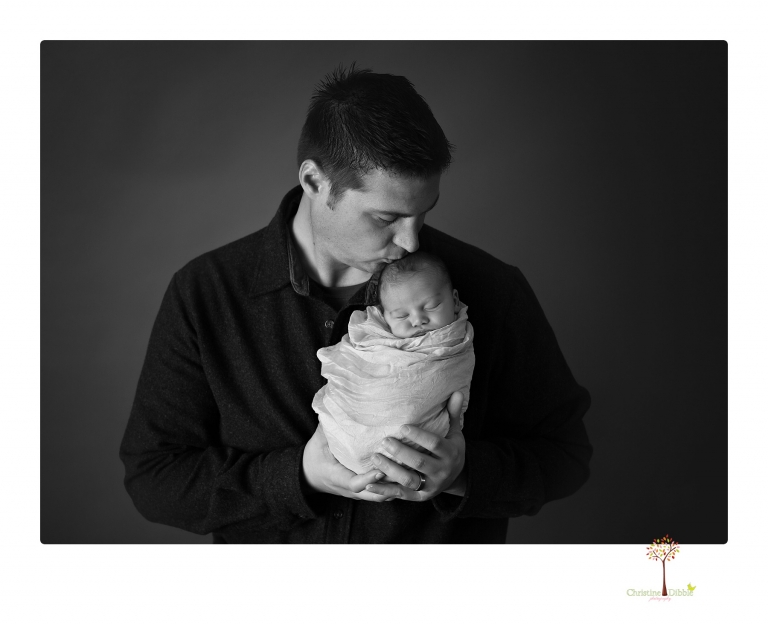 Sonora Newborn Photographer Christine Dibble Photography takes newborn portraits of a baby in a ski boot and with his parents.