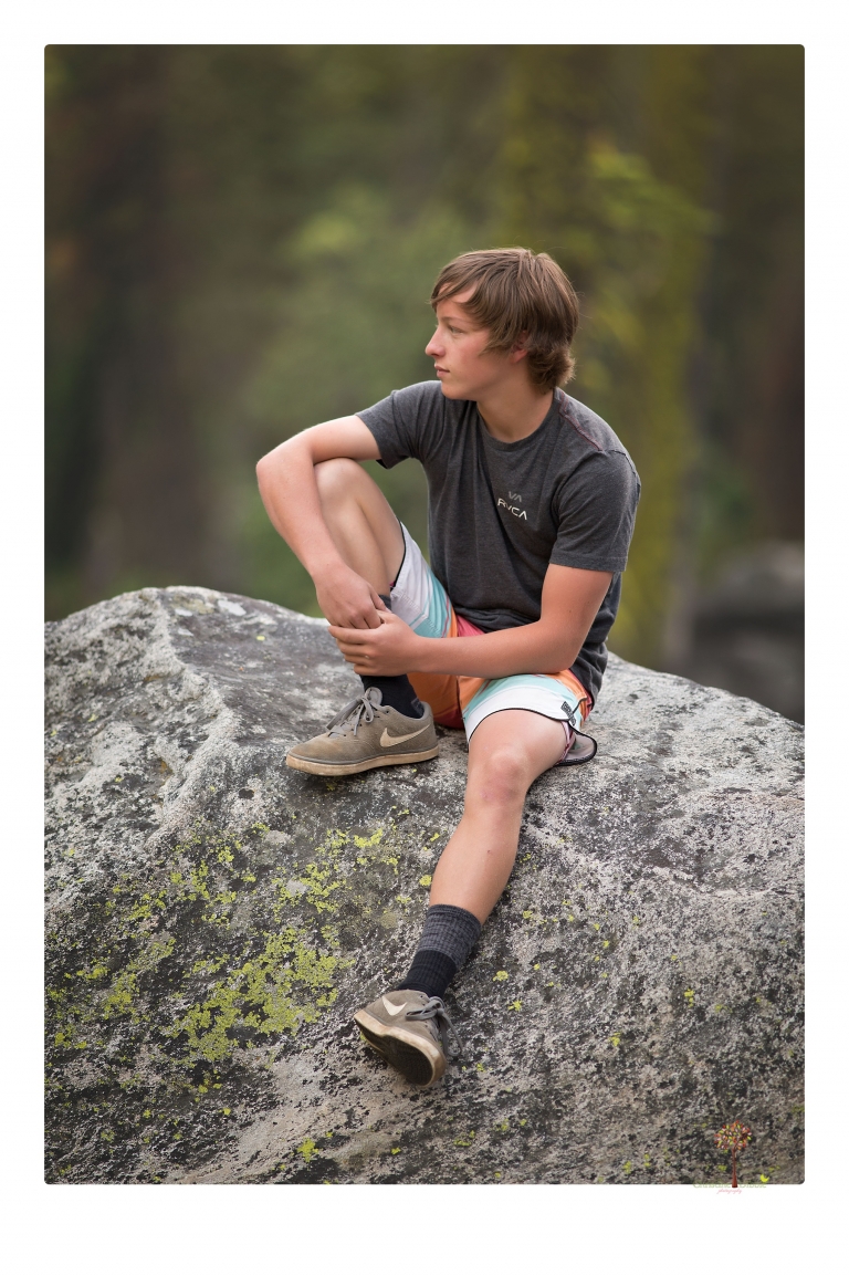 Summerville High School Senior portrait photographer Christine Dibble Photography takes four wheeling senior portraits of a boy with his trap gun, letterman jacket, and Toyota 4Runner as he drives over rocks and dives off cliffs.