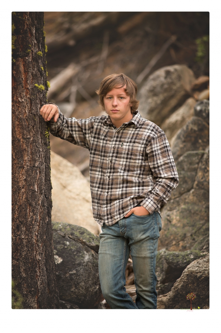 Summerville High School Senior portrait photographer Christine Dibble Photography takes four wheeling senior portraits of a boy with his trap gun, letterman jacket, and Toyota 4Runner as he drives over rocks and dives off cliffs.