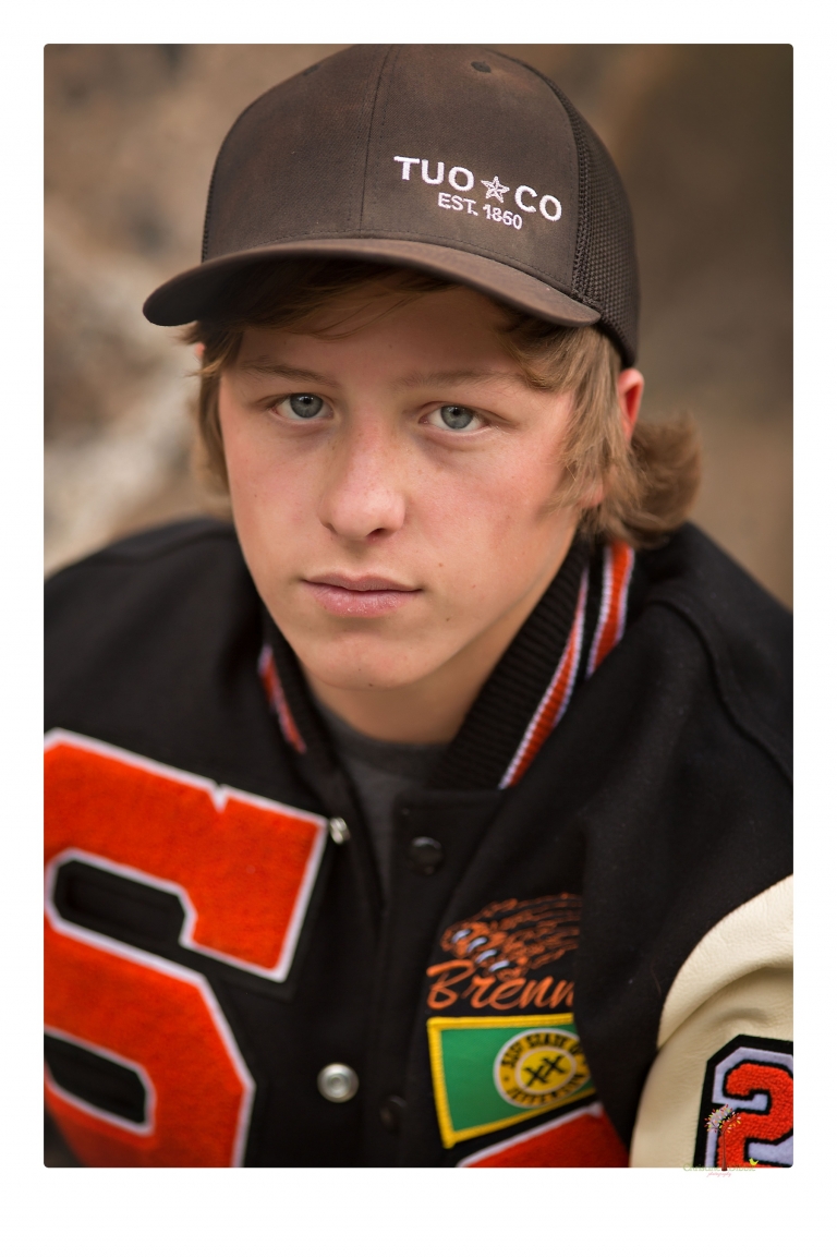 Summerville High School Senior portrait photographer Christine Dibble Photography takes four wheeling senior portraits of a boy with his trap gun, letterman jacket, and Toyota 4Runner as he drives over rocks and dives off cliffs.